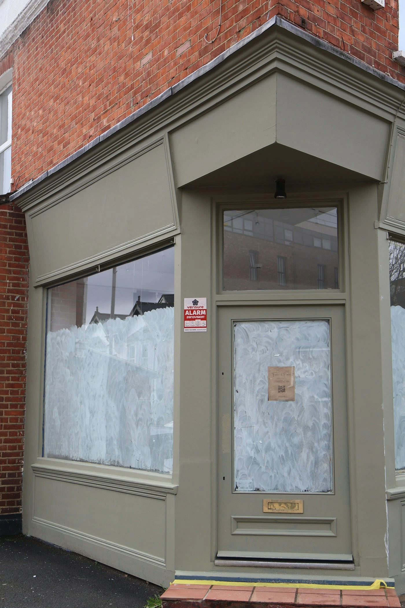 A commercial shopfront temporarily secured after a glass incident.