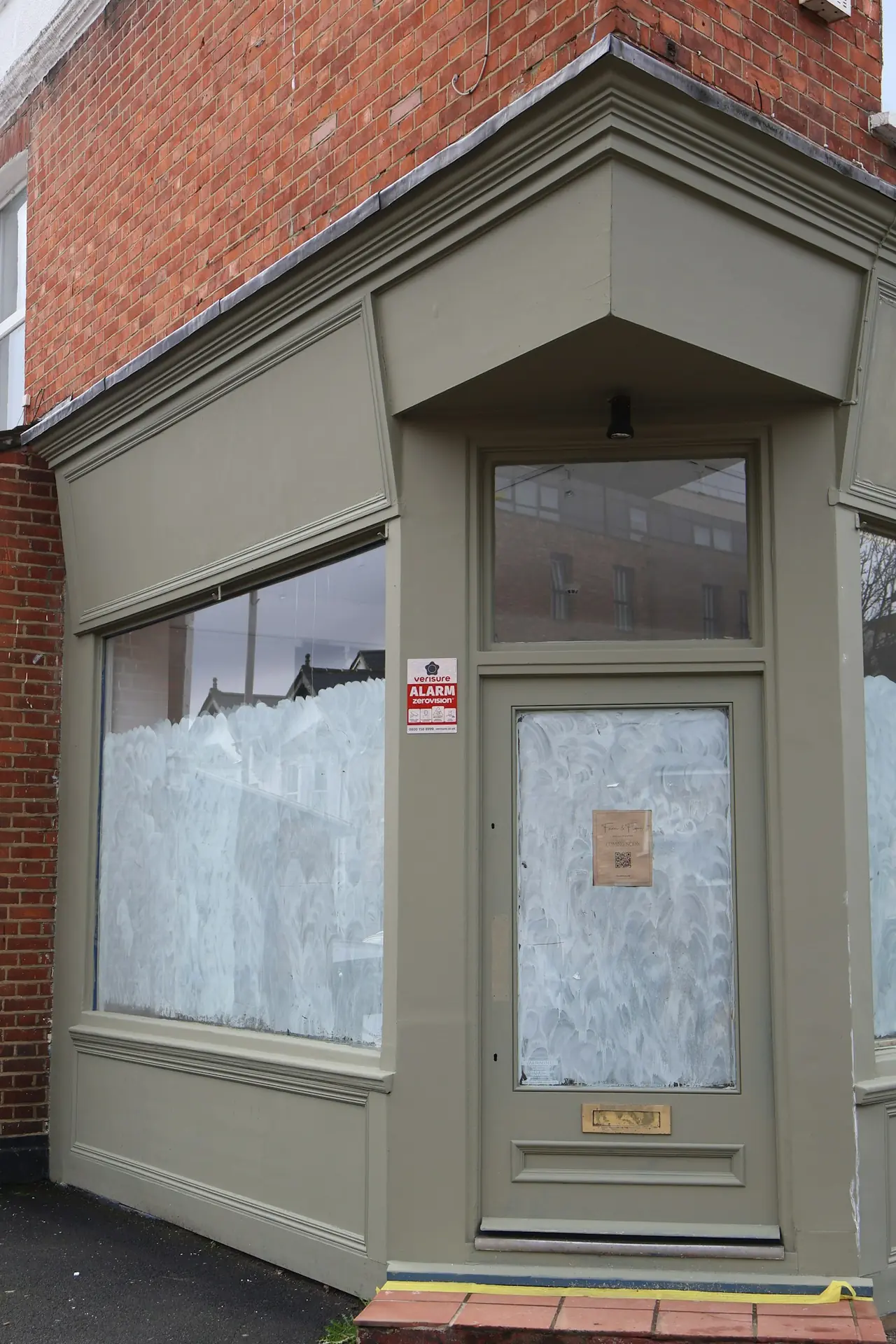 A commercial shopfront temporarily secured after a glass incident