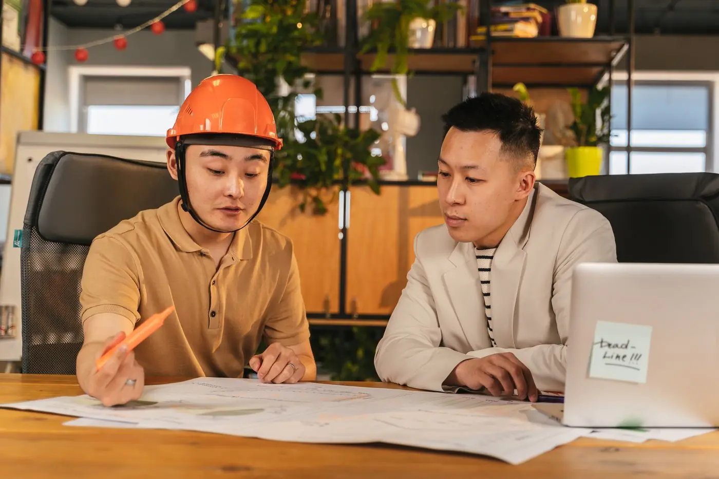 A site coordinator and office colleague reviewing plans together.