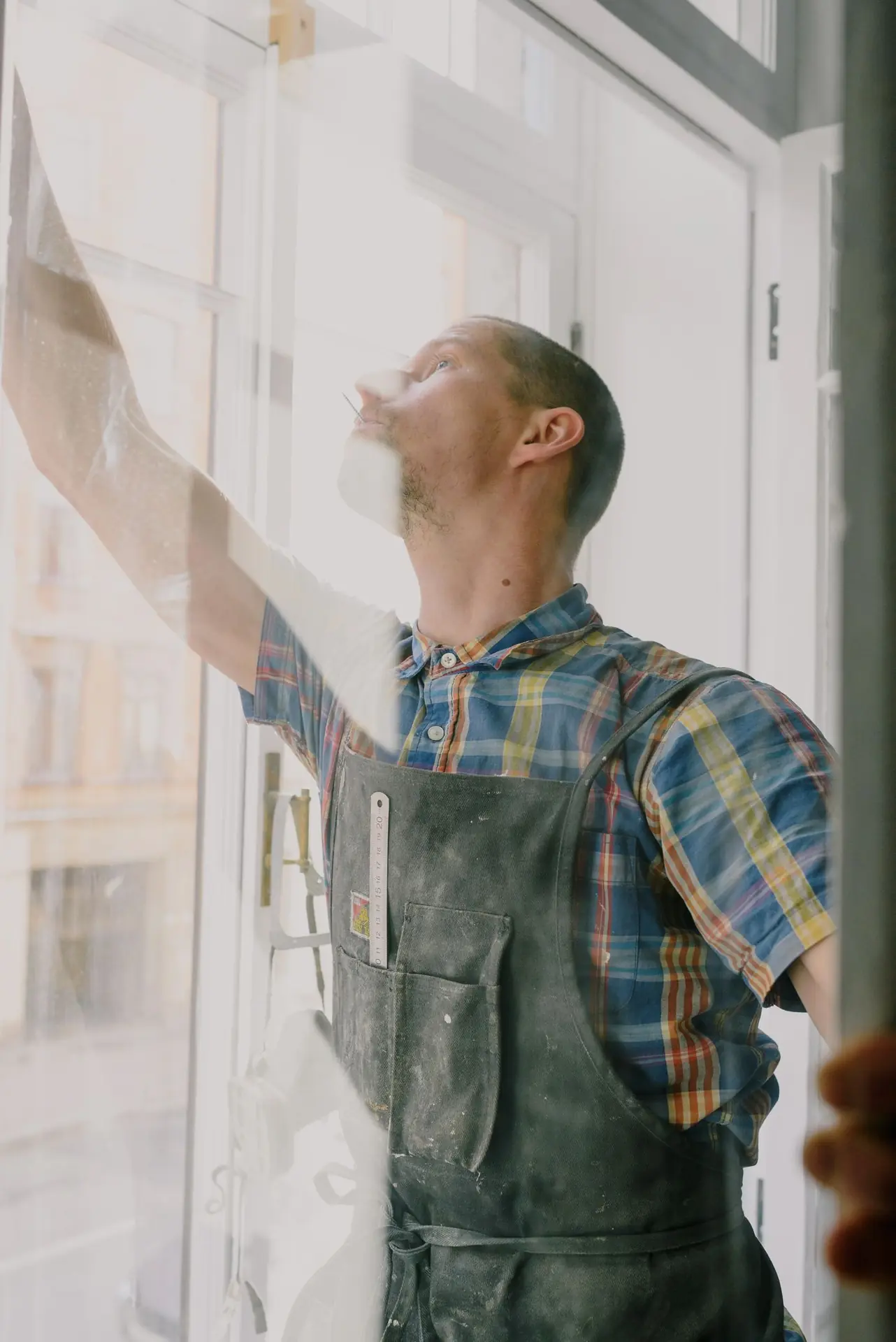 A skilled window installer checking the fit of a glazed opening.