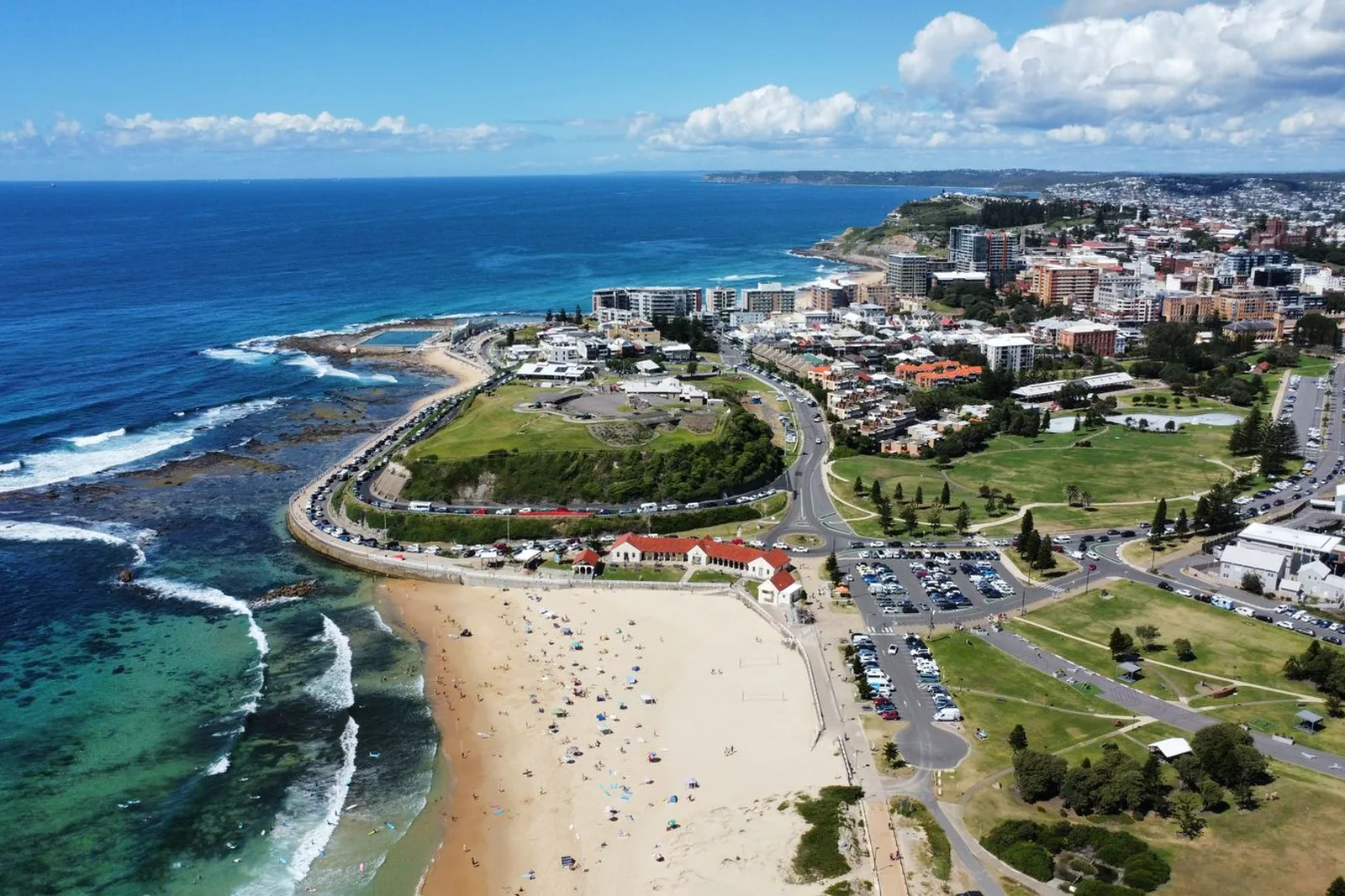 Newcastle's Nobbys Beach and coastal headland in daylight