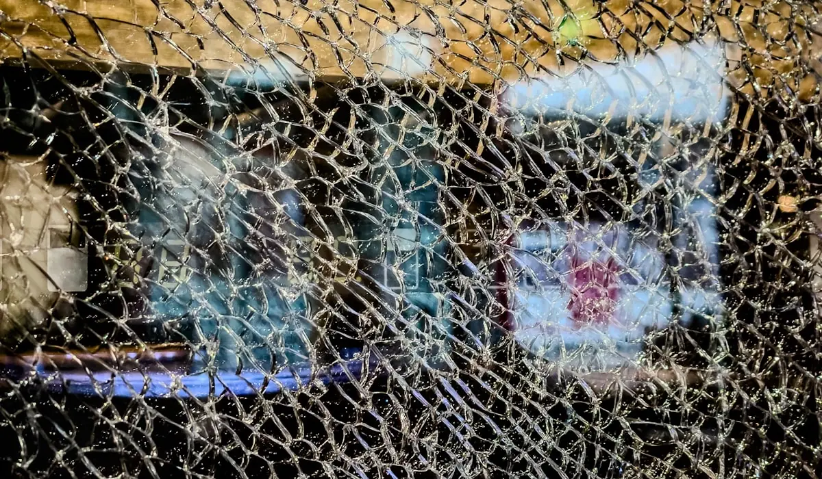 Badly shattered glass still held within a window frame.