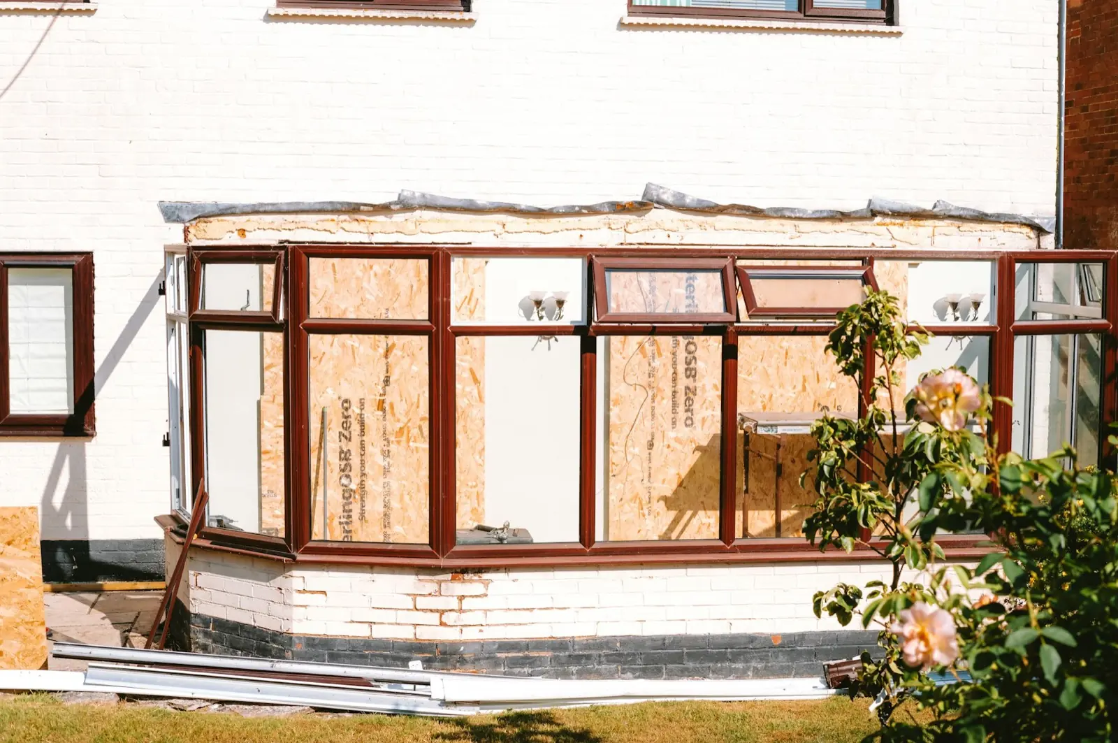 Plywood panels temporarily securing damaged glazed openings.