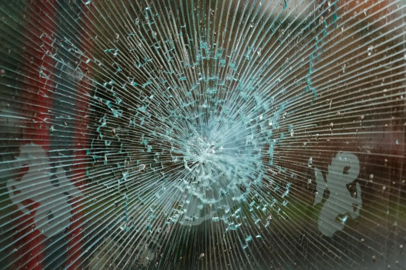 Impact damage and cracking across a glass pane.