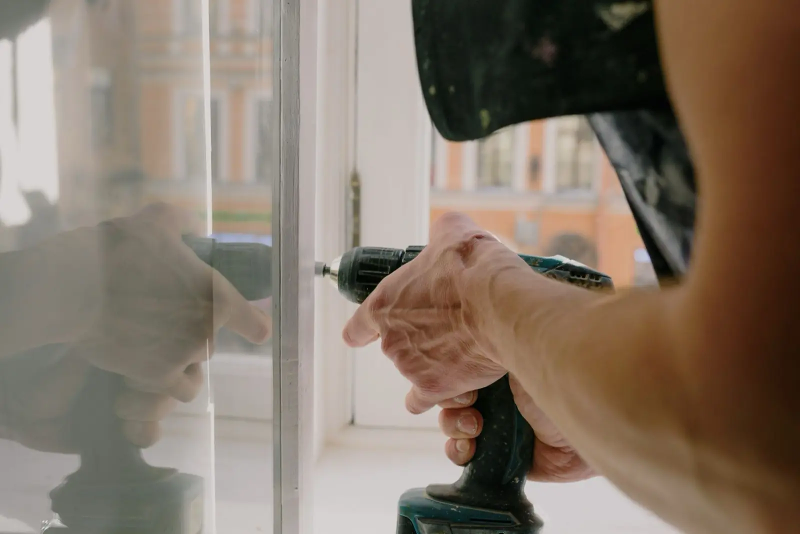 A tradesperson working on a window at an existing property.